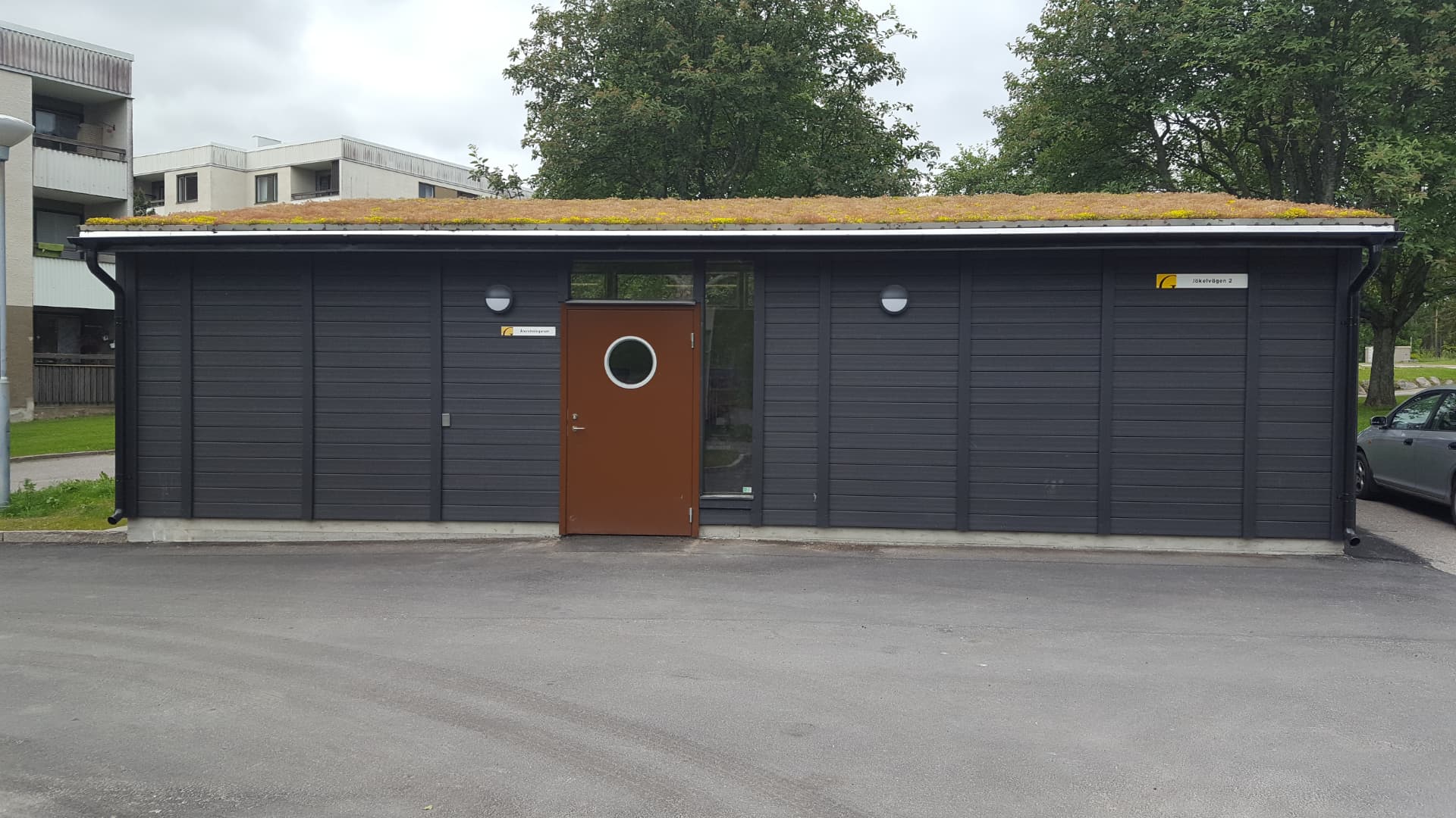 Miljöhus med sedumtak och mörkgrå fasad levererat till en bostadsfastighet
