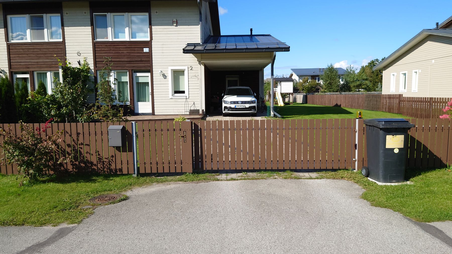 Staket i komposit med grind framför villa